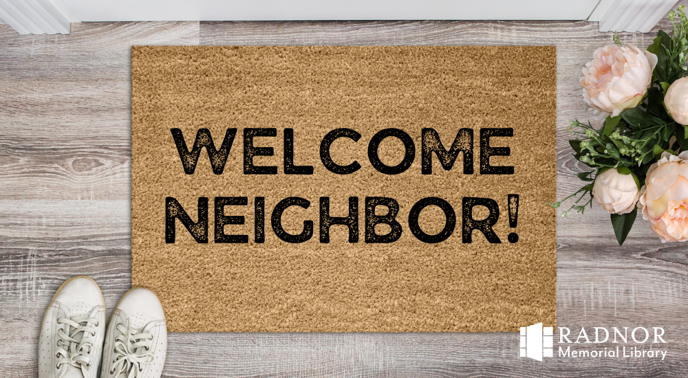 A welcome mat on a gray porch with the words Welcome Neighbor